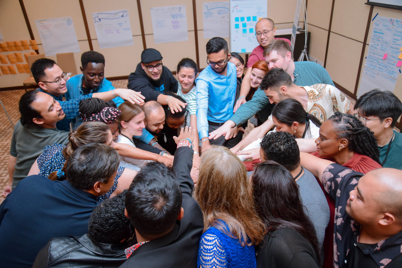 A group of CSP Fellows coming together in a circle