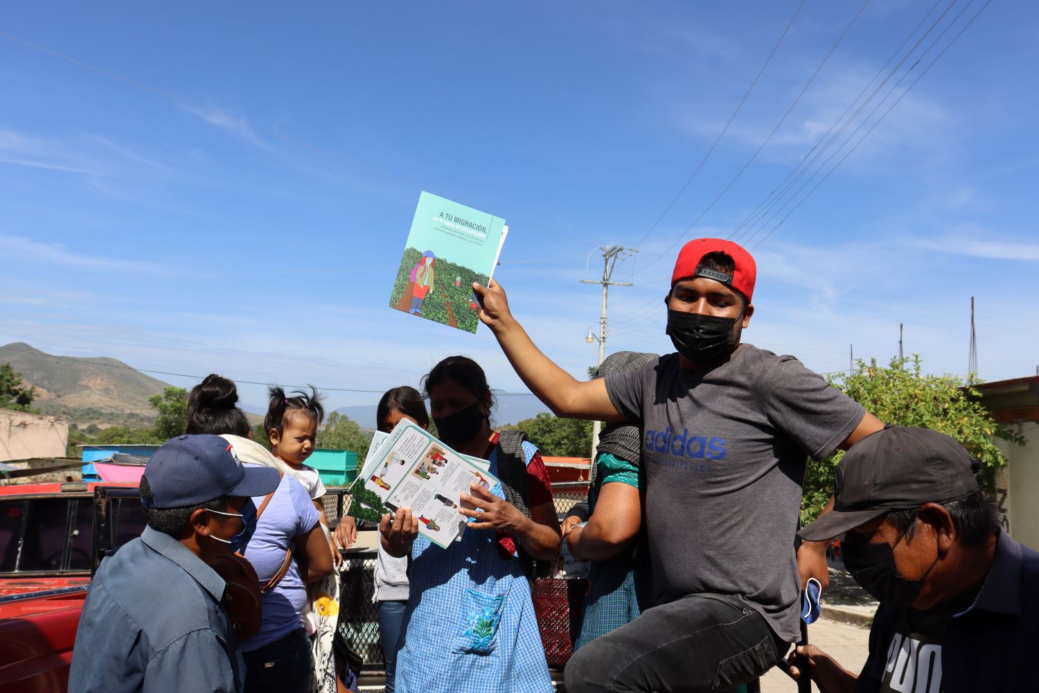 An image of migrants holding training materials about safe migration