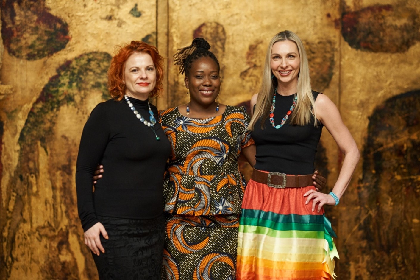 Three women standing and smiling