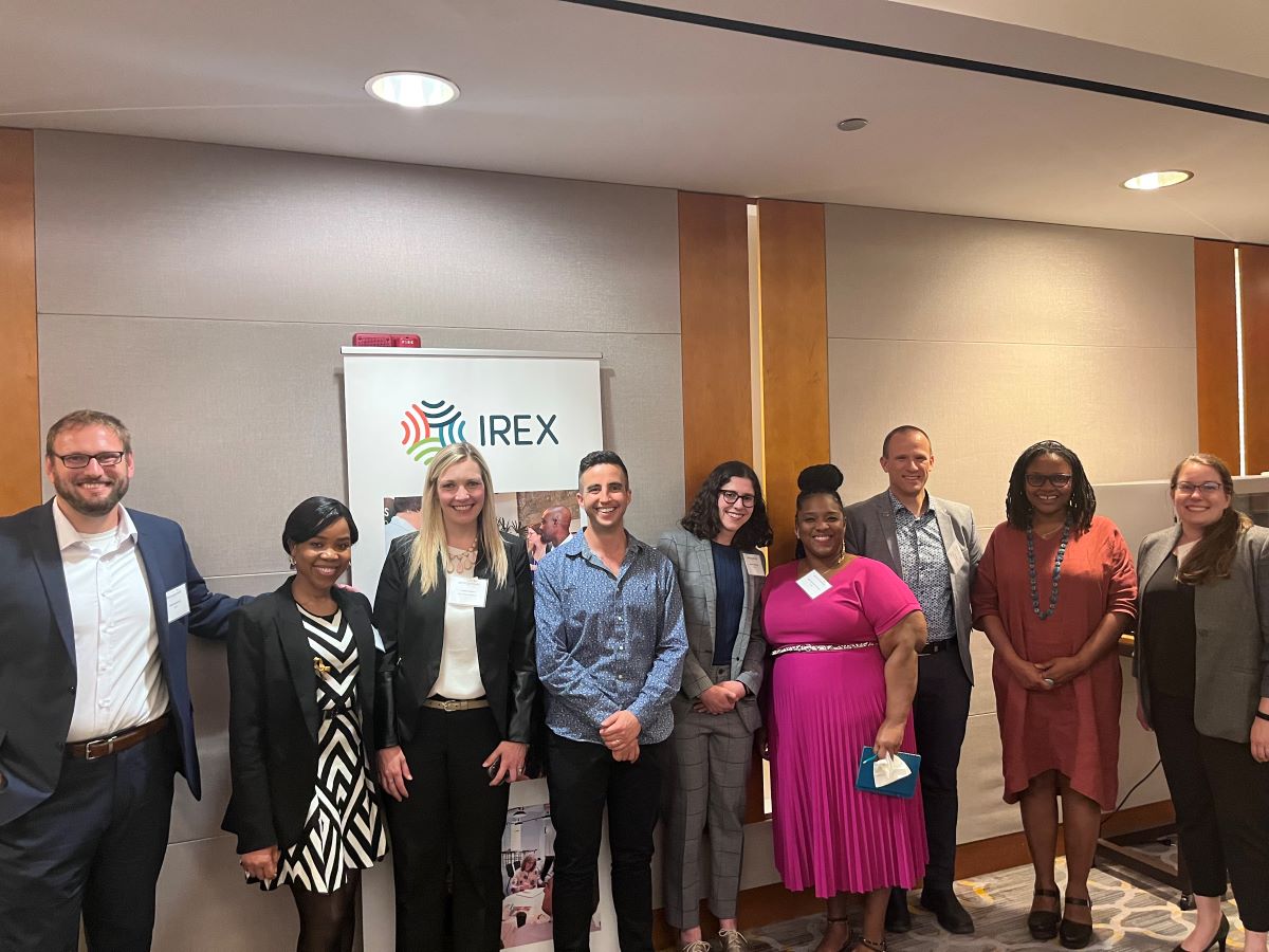 A group of people at a conference standing and smiling