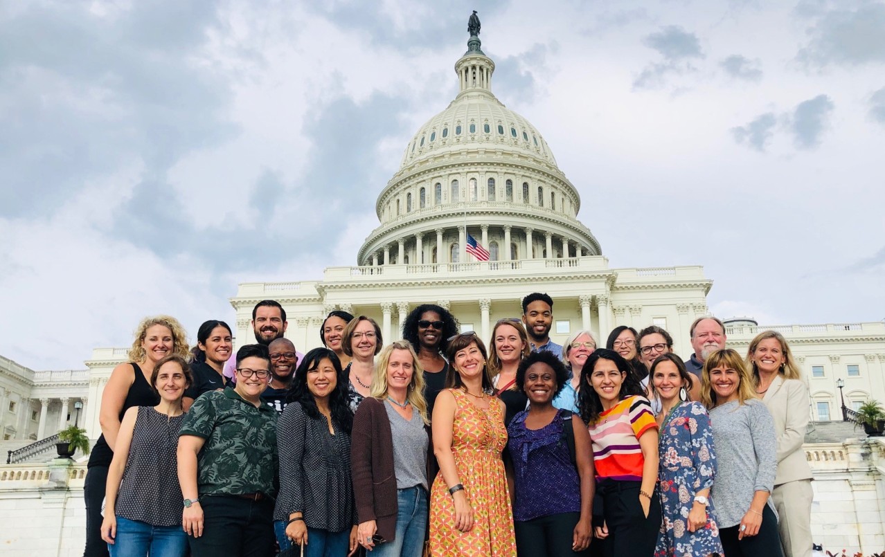 Group of people stand in front of Capitol Hill