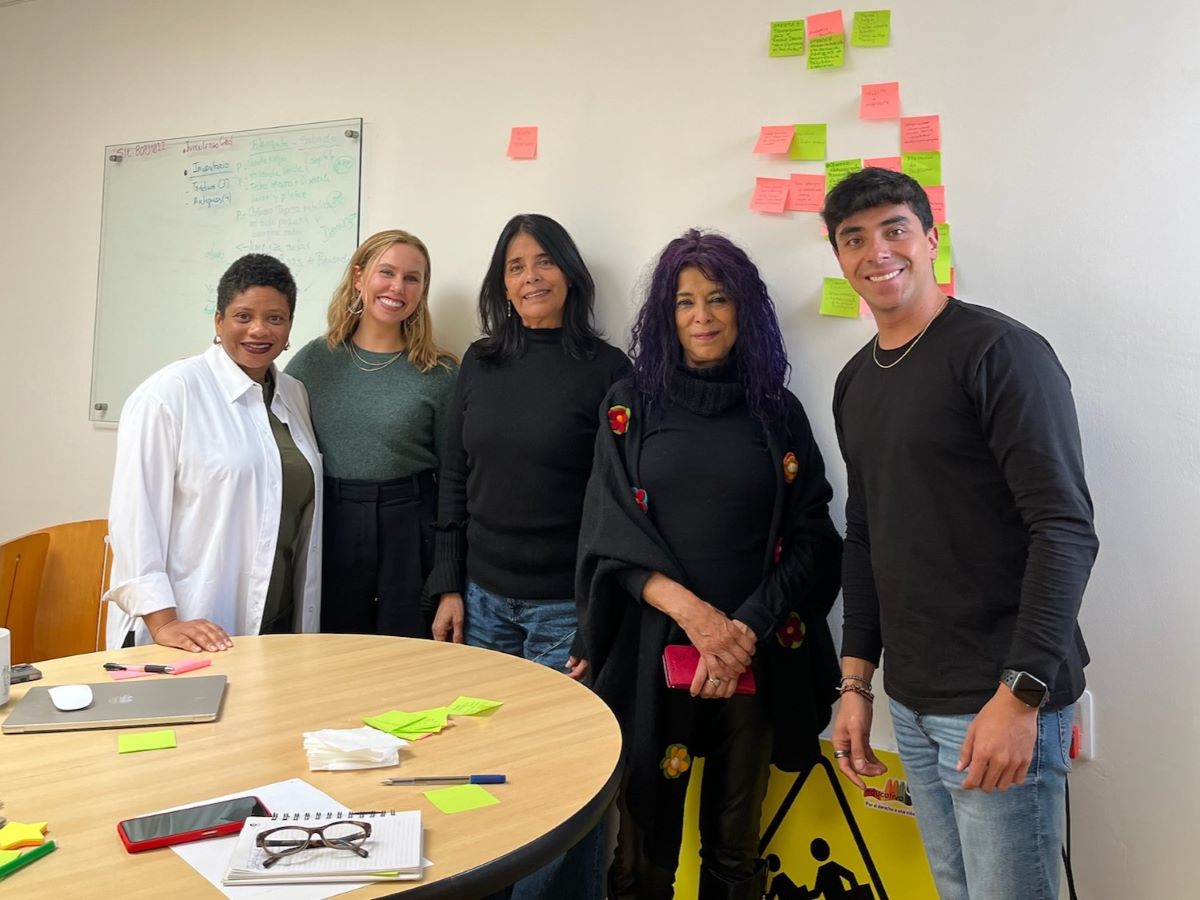 A group of people standing in a classroom smiling.